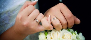 Hands with rings and wedding bouquet